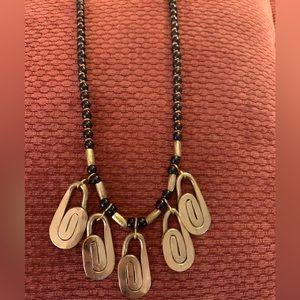 Copper charms on a beaded necklace with black beads and brass dividers